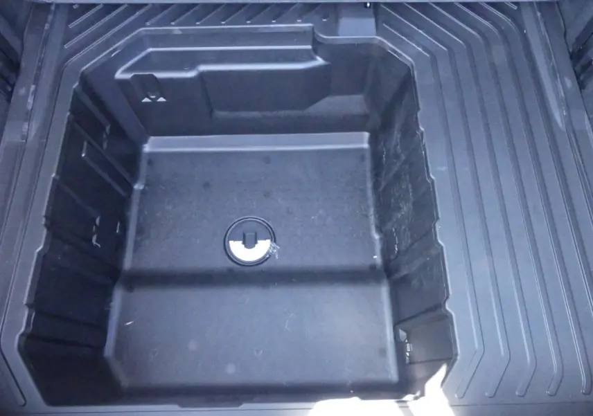 Vue plongeante sur le compartiment de rangement sous le plancher du coffre du Ford Puma gris métallisé 2025.