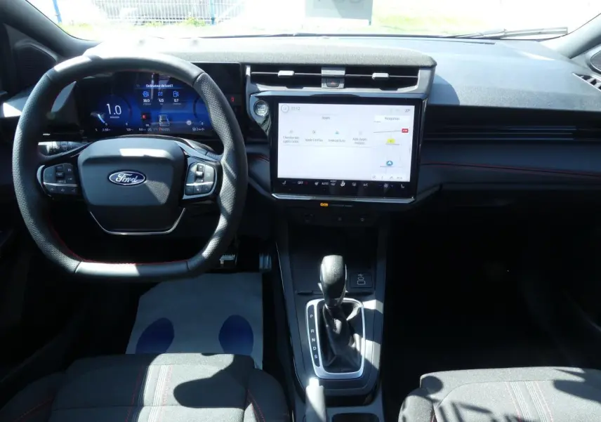 Vue intérieure du tableau de bord du Ford Puma 2025, avec écran tactile central et volant multifonction noir.