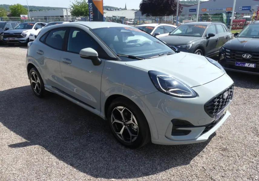 Ford Puma 2025 gris métallisé en 3/4 avant droit, avec jantes alliage et calandre noire sportive ST-Line.