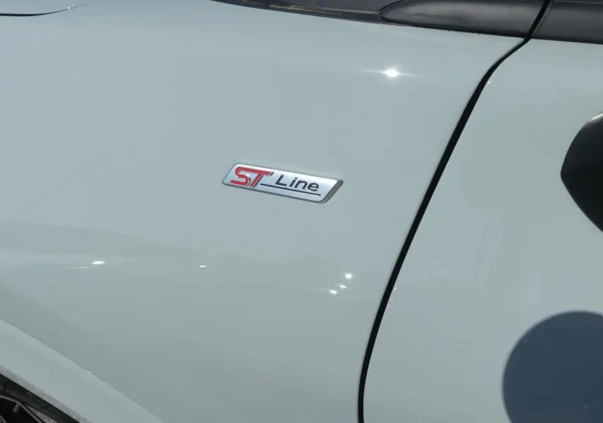 Gros plan sur l'emblème ST-Line sur la porte avant gauche d'un Ford Puma gris métallisé 2025.