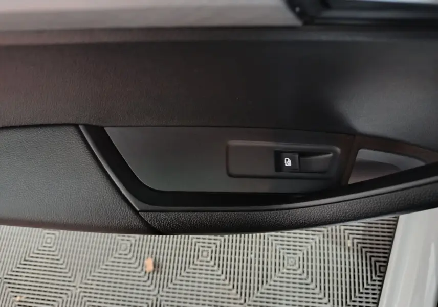 Détail de la poignée intérieure de la porte côté gauche d'un Skoda Karoq 2.0 TDI 2024 avec bouton de verrouillage noir.