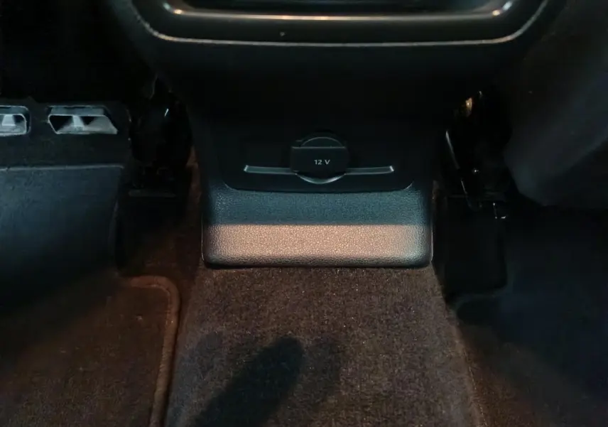 Prise 12V noire en bas de la console centrale, vue rapprochée de l'intérieur du Skoda Karoq 2024.