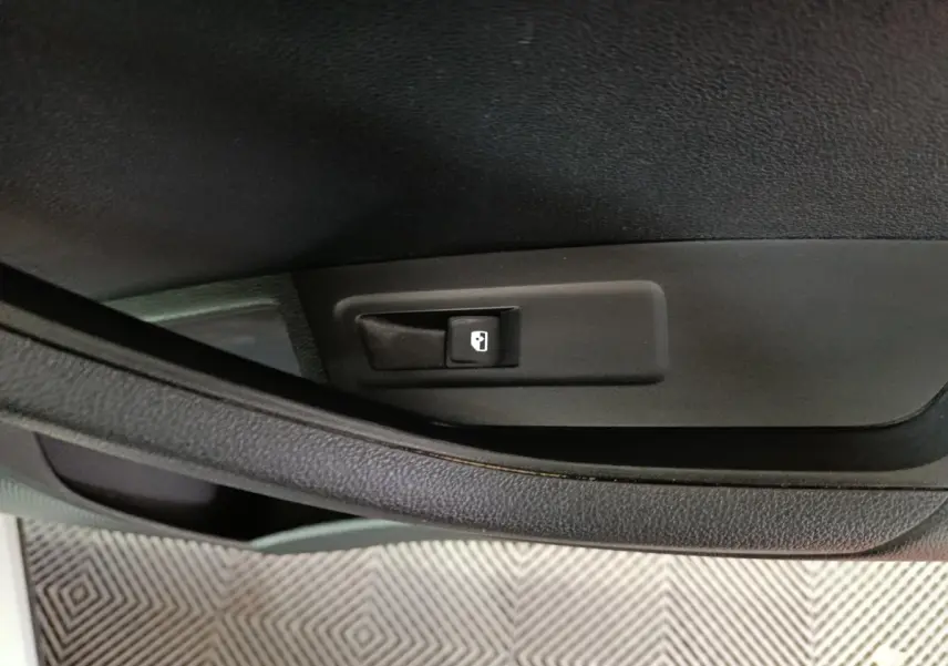 Gros plan sur la poignée intérieure noire de porte côté conducteur du Skoda Karoq 2024, finition Selection.