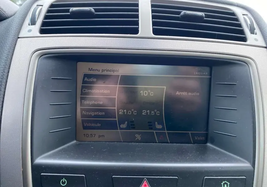 Écran central de la Jaguar XK 2009 gris clair montrant le menu principal avec climatisation et audio.