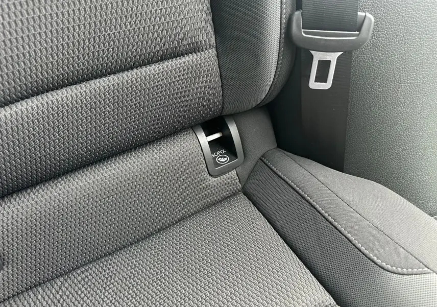 Gros plan sur l'assise arrière noire de la Volkswagen Golf VII avec fixation ISOFIX et ceinture de sécurité visible.