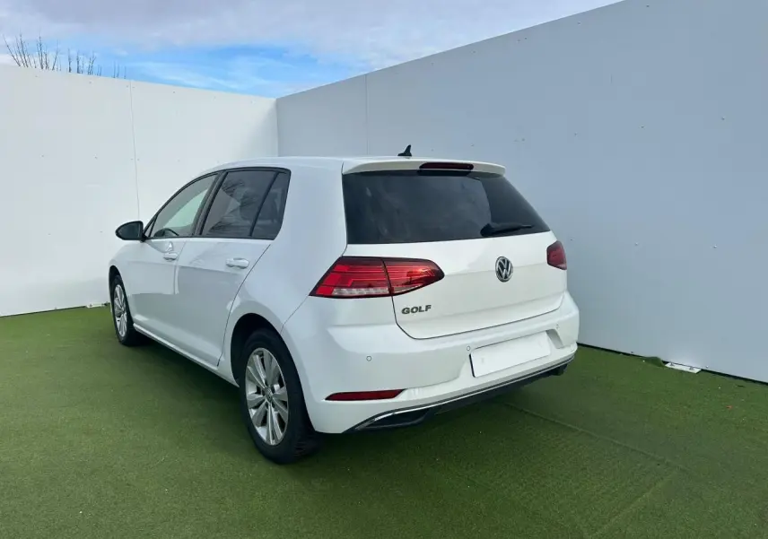 Vue 3/4 arrière droite d'une Volkswagen Golf blanche 5 portes avec feux arrière LED et jantes alliage 16 pouces.