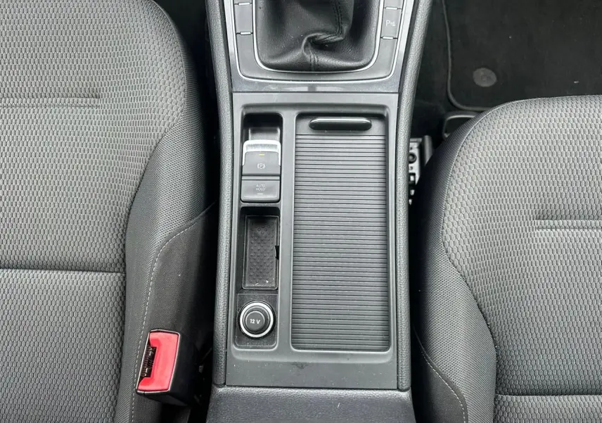 Vue plongeante sur la console centrale noire et les sièges tissu gris de la Volkswagen Golf VII 2.0 TDI.