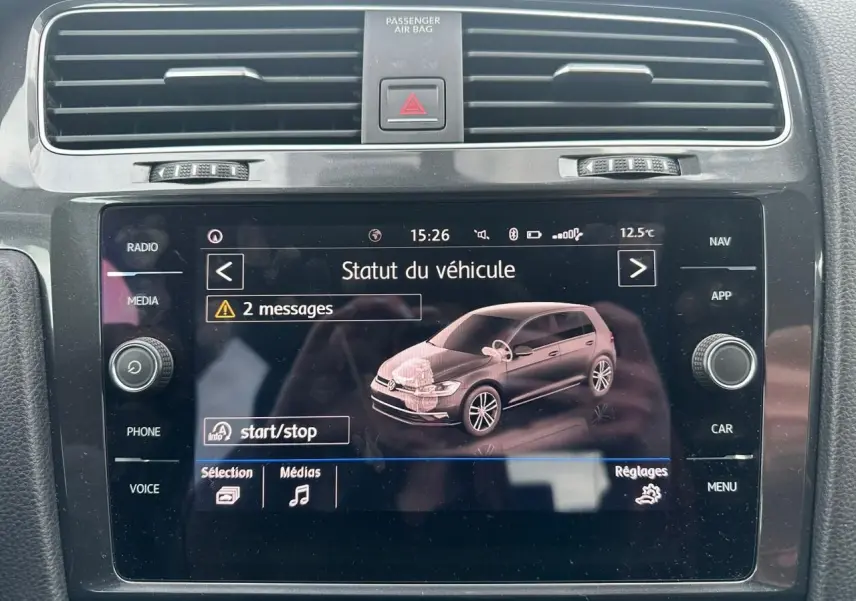 Écran tactile central affichant le statut du véhicule Volkswagen Golf VII, vue intérieure du tableau de bord noir.