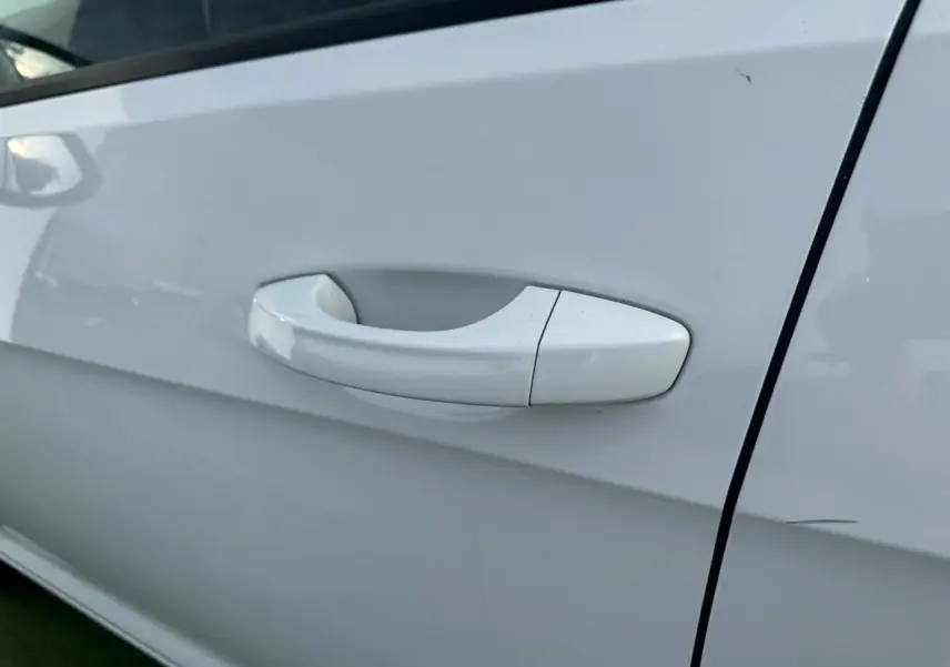 Poignée de porte blanche côté droit d'une Volkswagen Golf VII 2.0 TDI 2018, finition Confortline.