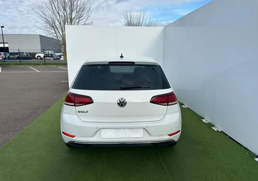 Vue arrière d'une Volkswagen Golf blanche VII 2.0 TDI avec feux arrière LED et pare-chocs couleur carrosserie.