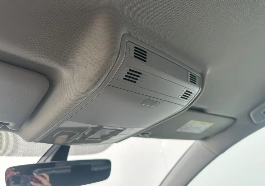 Vue intérieure du plafond avant gris clair de la Volkswagen Golf VII avec plafonnier et bouches d'aération intégrées.