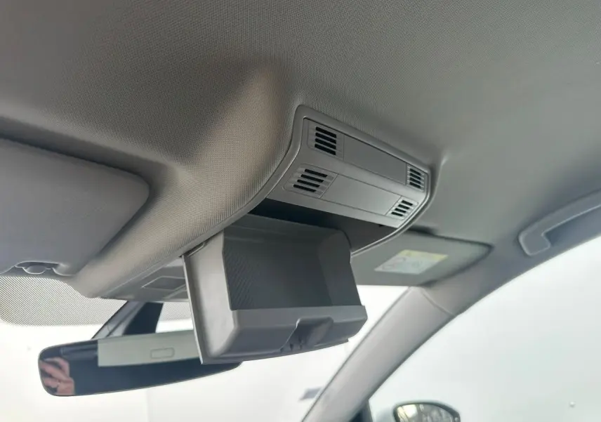 Détail du rangement plafond ouvert au-dessus du rétroviseur intérieur dans une Volkswagen Golf VII blanche de 2018.