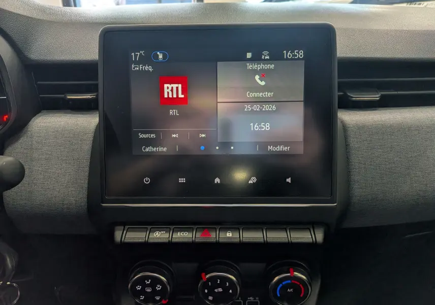 Vue rapprochée de l’écran tactile central et des commandes de climatisation d’une Renault Clio V 2024, intérieur gris.