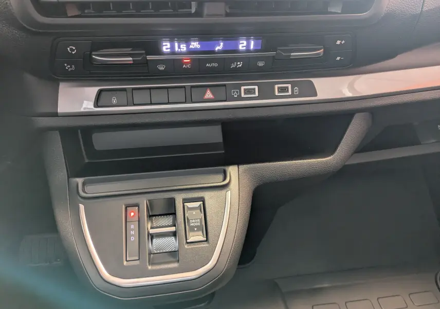 Détail de la console centrale du Peugeot Traveller 2026 noir, avec commandes de climatisation et boîte automatique.