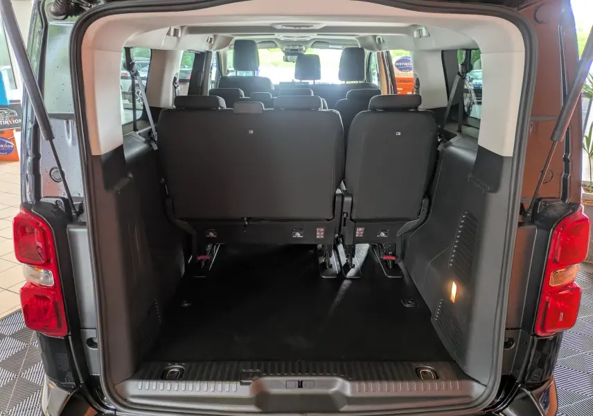Vue arrière ouverte du Peugeot Traveller noir 2026, montrant l'espace intérieur avec sièges arrière et plancher dégagé.