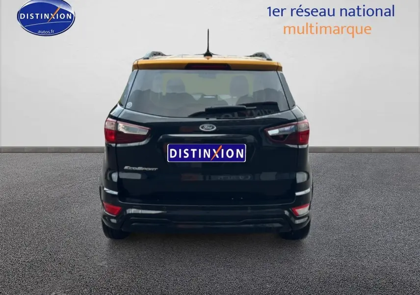 Vue arrière d'un Ford EcoSport noir avec toit orange, mettant en valeur ses feux et barres de toit visibles.