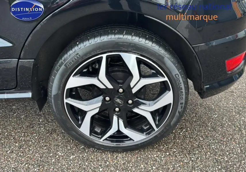 Gros plan sur la roue avant droite du Ford EcoSport noir avec jante alu bicolore et logo Ford visible.