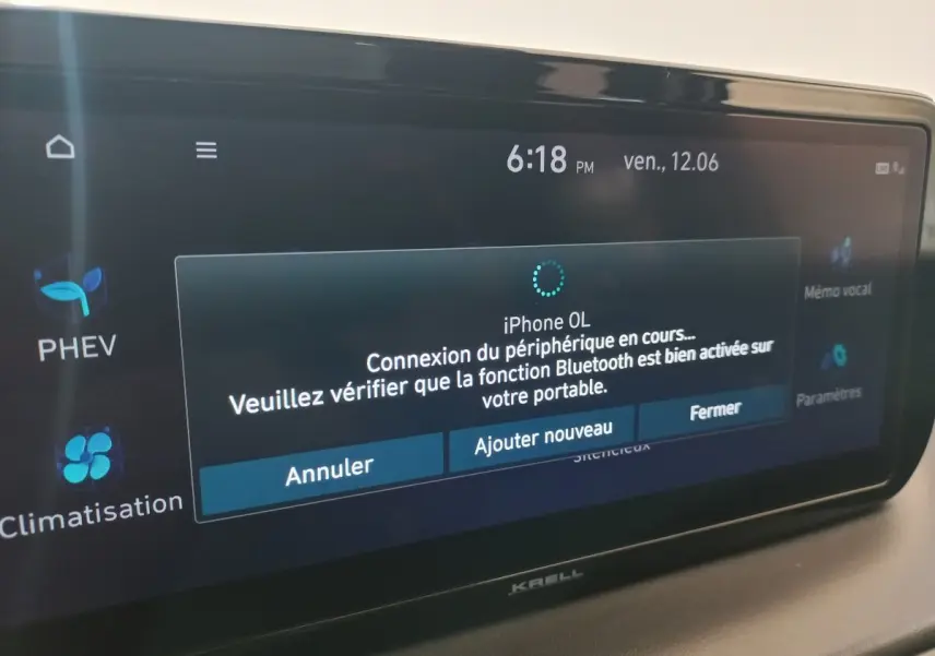 Écran tactile intérieur du Hyundai Santa Fe hybride, affichant la connexion Bluetooth en cours à l’iPhone.