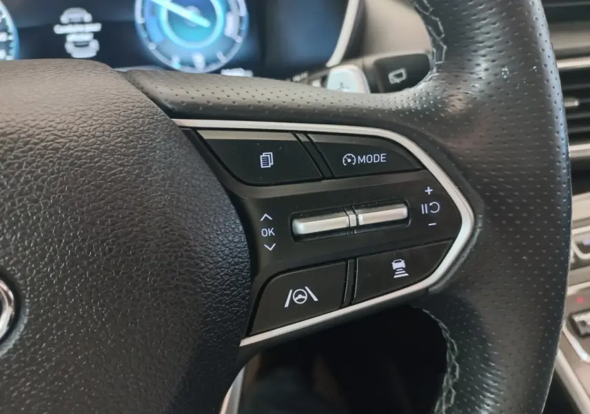 Gros plan sur les commandes multifonctions du volant cuir noir du Hyundai Santa Fe hybride rechargeable 2021.