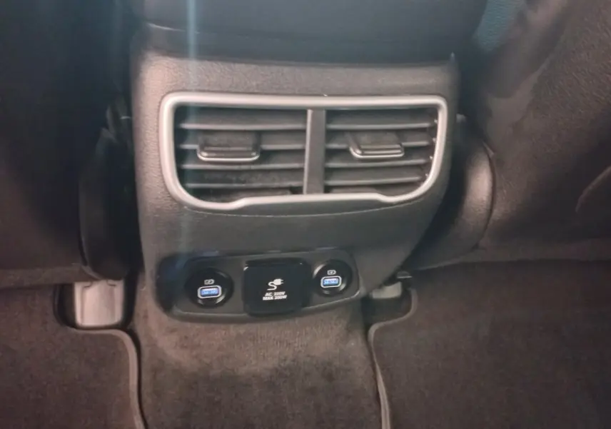 Vue rapprochée des aérateurs arrière et des prises USB bleues du Hyundai Santa Fe hybride rechargeable gris clair.