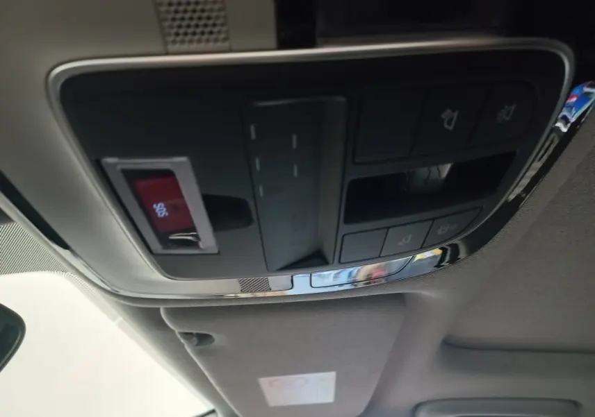 Vue intérieure du panneau de commandes au plafond du Hyundai Santa Fe gris clair, avec bouton SOS rouge visible.