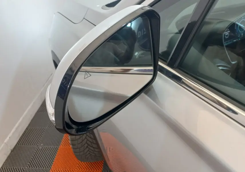 Rétroviseur extérieur droit gris clair du Hyundai Santa Fe hybride rechargeable, vue rapprochée sur la portière et la vitre.