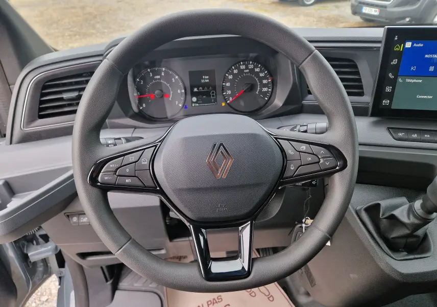 Vue rapprochée du volant multifonction gris du Renault Master 2026 avec tableau de bord et écran tactile visible.