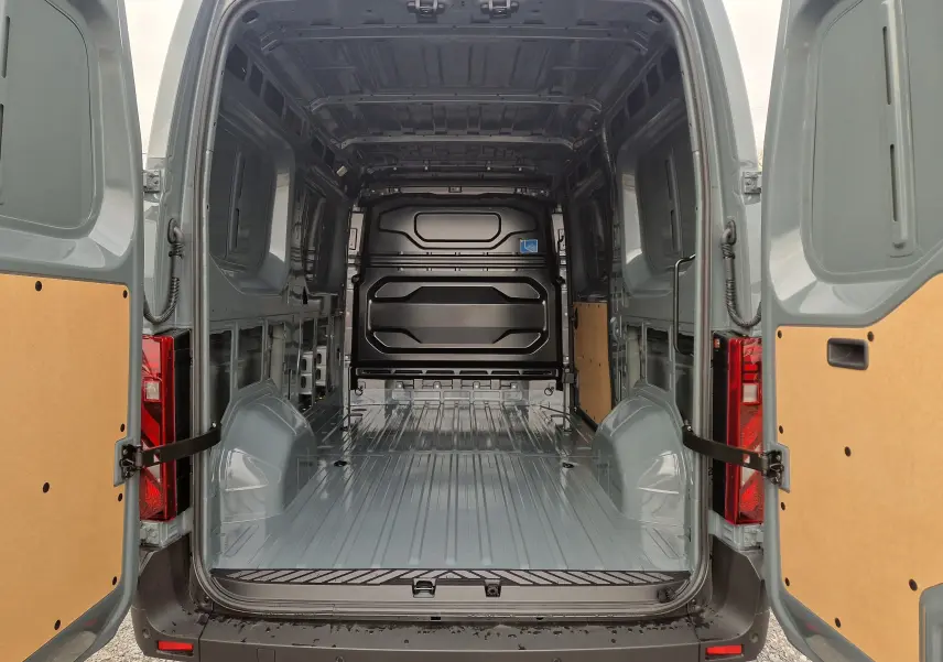 Vue arrière ouverte du Renault Master L2H2 gris urbain montrant l'espace de chargement vide avec parois partiellement protégées.