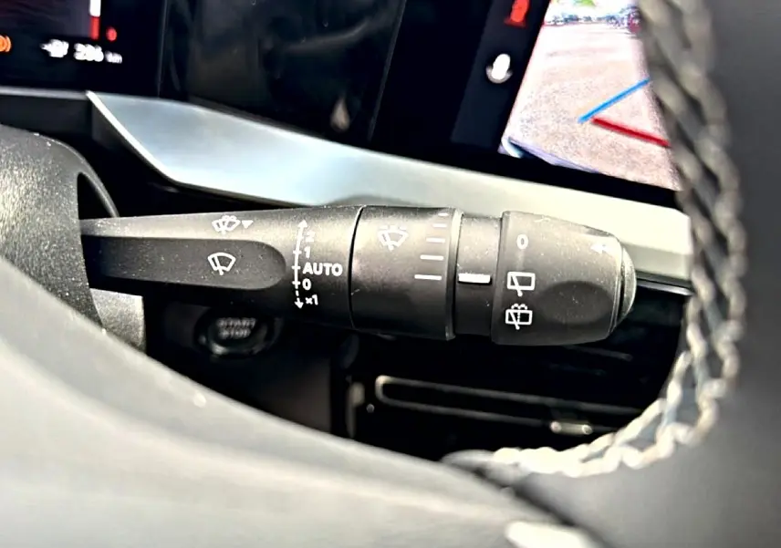 Gros plan sur la commande des essuie-glaces à gauche du volant dans l’habitacle de l’Opel Mokka Electric 2025.