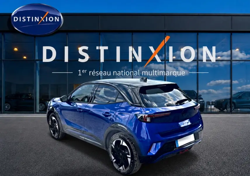 Opel Mokka Electric bleu en 3/4 arrière droit, toit noir brillant et jantes alu distinctives.