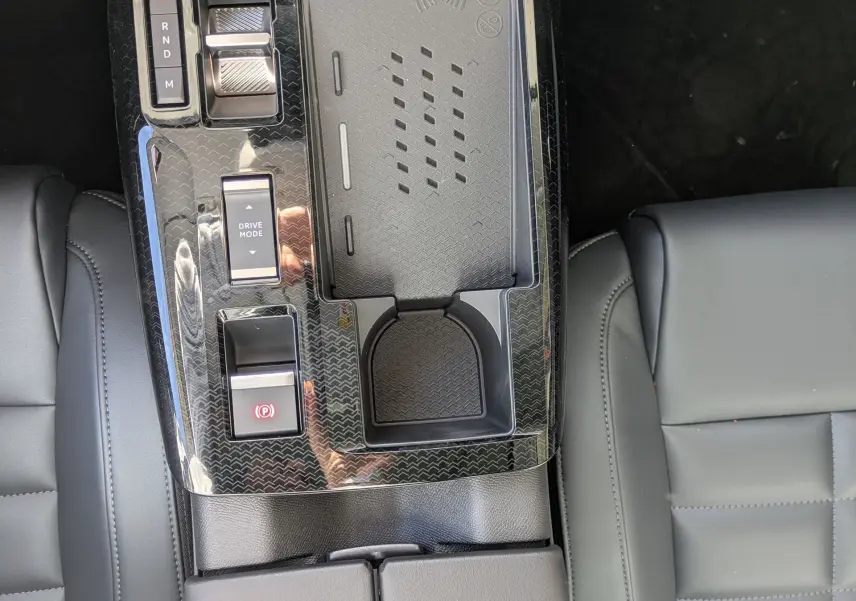 Vue plongeante sur la console centrale noire brillante du Citroën C5 Aircross hybride avec sièges cuir gris.