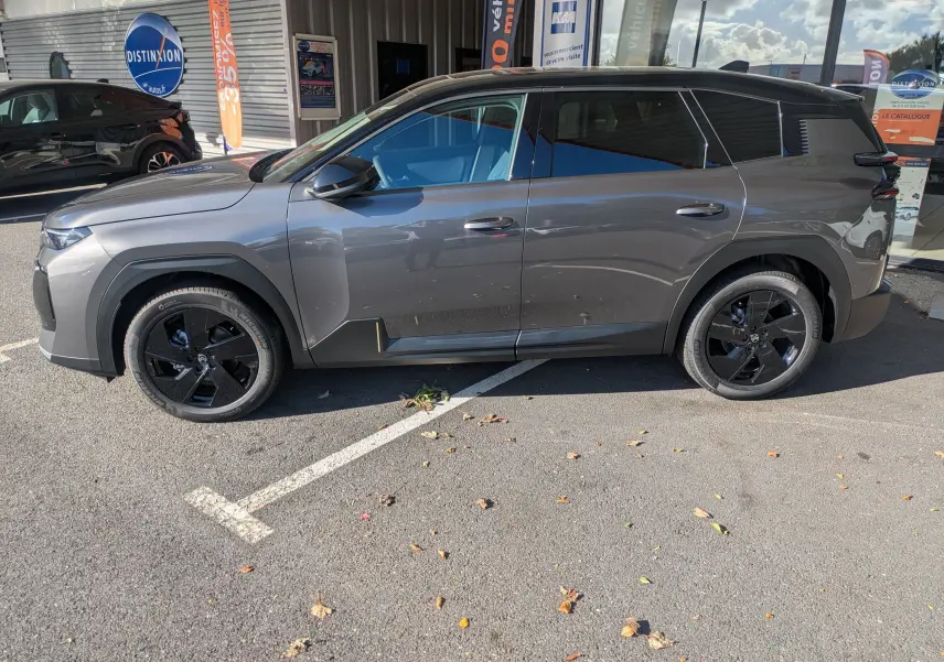 Vue de profil côté gauche d'un Citroën C5 Aircross hybride gris platinium avec toit noir et jantes noires.