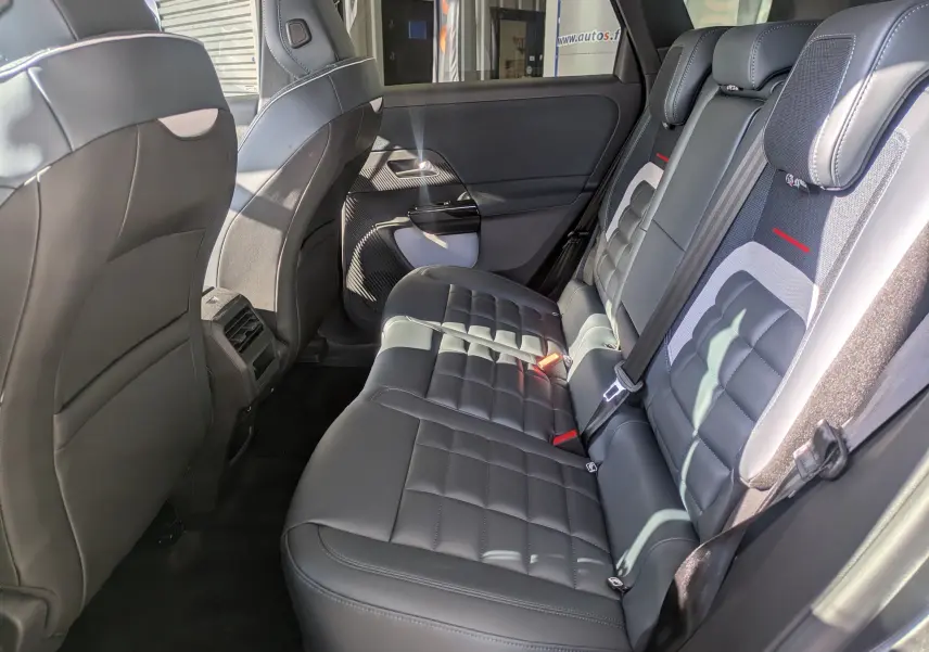 Vue intérieure arrière droite du Citroën C5 Aircross hybride 2026, sièges cuir noirs avec surpiqûres et appuie-têtes intégrés.