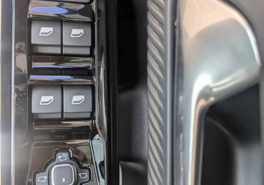 Gros plan sur les commandes de lève-vitres et rétroviseurs côté conducteur du Citroën C5 Aircross hybride 2026, intérieur noir.