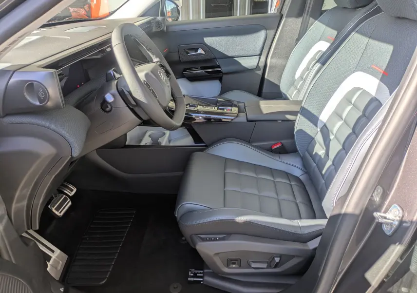 Vue intérieure côté conducteur du Citroën C5 Aircross hybride 2026, sièges cuir gris et tableau de bord moderne.