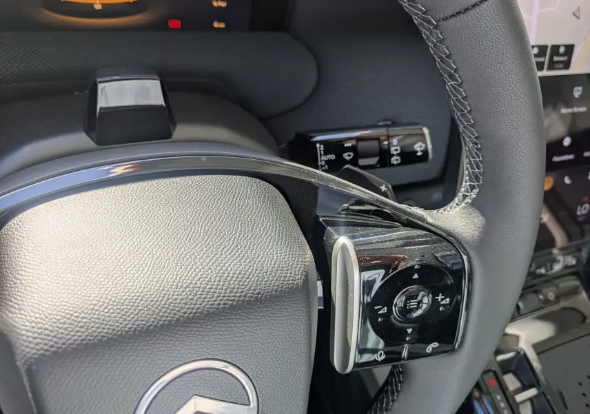 Gros plan sur le volant noir du Citroën C5 Aircross hybride 2026, avec commandes intégrées et coutures apparentes.