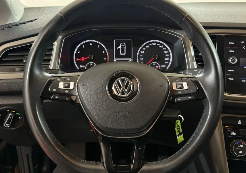 Vue centrée sur le volant cuir noir du Volkswagen T-Roc 2020 avec tableau de bord numérique et commandes multifonctions.