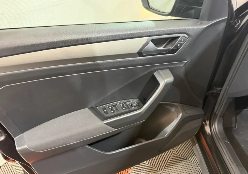Vue rapprochée de la porte avant gauche noire du Volkswagen T-Roc 2020 avec commandes électriques et poignée angulaire.