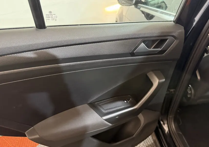 Gros plan sur la porte arrière gauche noire du Volkswagen T-Roc 2020, avec poignée et commande de fenêtre visible.