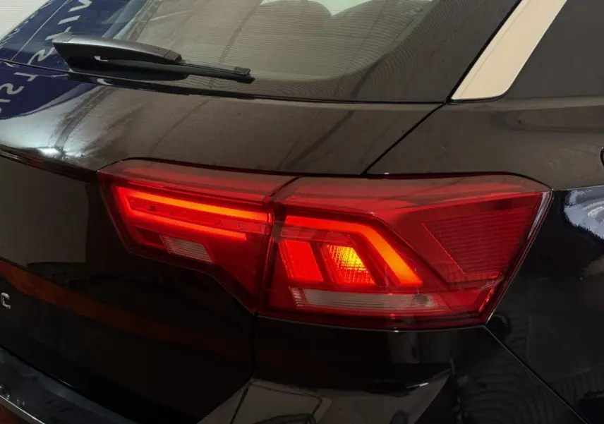 Feu arrière droit allumé d'un Volkswagen T-Roc noir 2020, vue rapprochée sur la partie arrière côté droit.