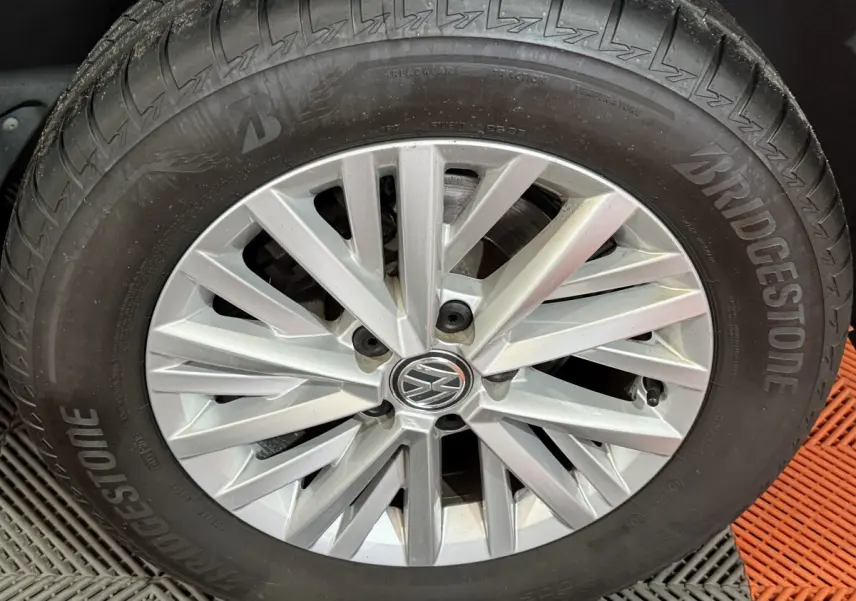 Gros plan sur la roue avant droite d’un Volkswagen T-Roc noir avec jante argentée et pneu Bridgestone.