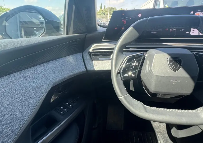 Vue intérieure côté conducteur du Peugeot 3008 Hybrid 136 Allure 2025, volant compact et tableau de bord numérique.