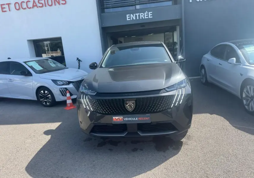 Peugeot 3008 Hybrid gris foncé vue de face, mettant en valeur la calandre et les feux LED distinctifs en griffes.