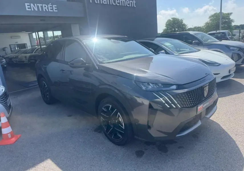 Peugeot 3008 Hybrid gris foncé en 3/4 avant droit, avec jantes alliage 19 pouces et calandre distinctive.