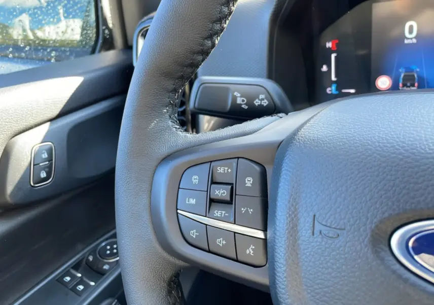 Gros plan sur le volant cuir multifonctions et commandes au volant côté gauche du Ford Ranger gris Iconic 2026.