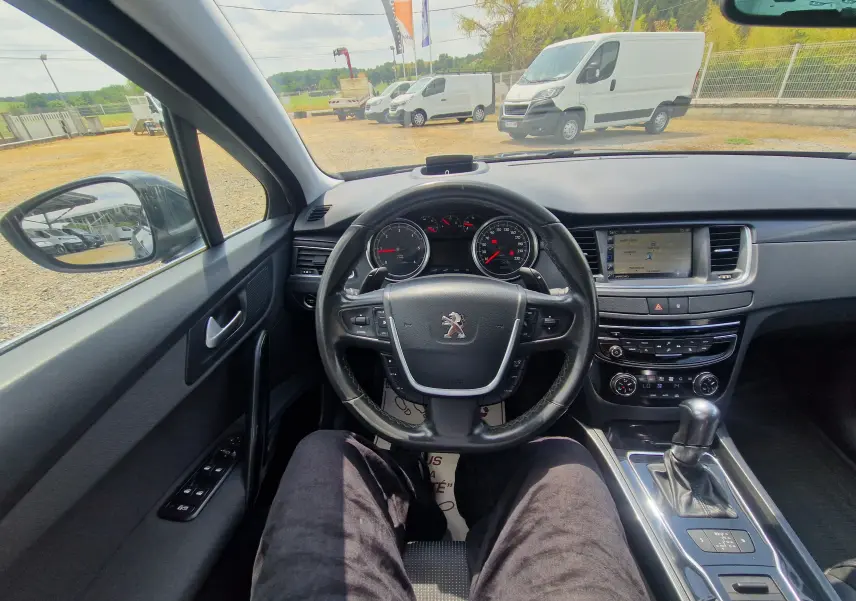 Vue intérieure de face du poste de conduite du Peugeot 508 SW gris Shark, avec volant multifonction et écran tactile central.