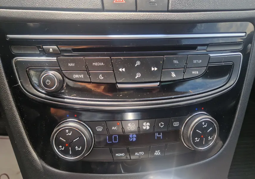 Gros plan sur la console centrale noire du Peugeot 508 SW 2015, montrant les commandes multimédia et climatisation digitale.