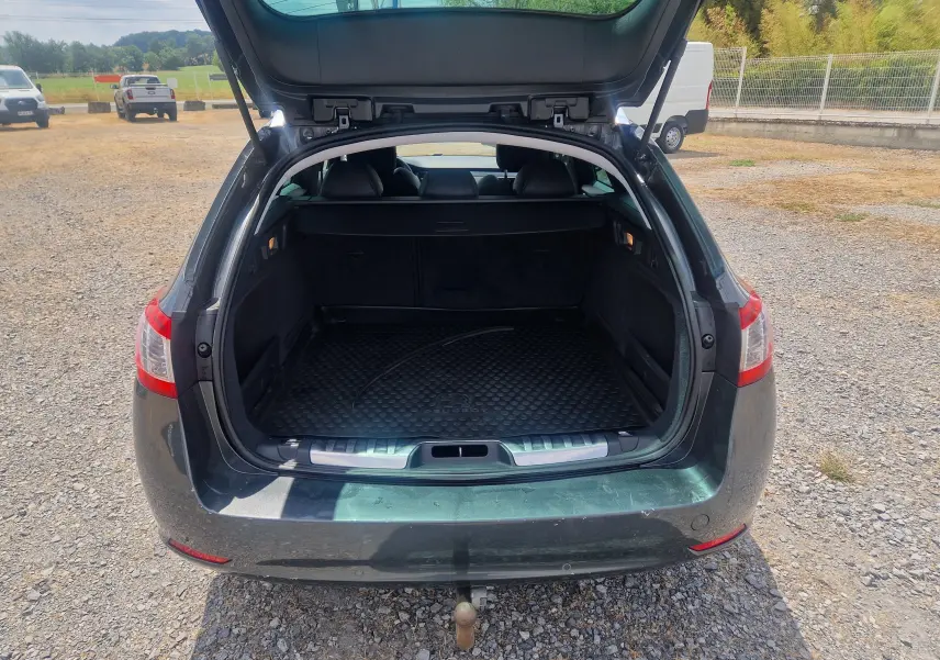 Vue arrière ouverte du coffre d'une Peugeot 508 SW gris Shark, montrant l'espace de chargement vide et le hayon relevé.