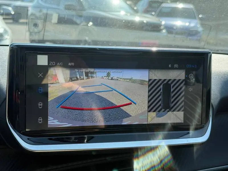 Écran tactile intérieur montrant la caméra de recul et vue 360° du Peugeot 208 gris Selenium en stationnement.