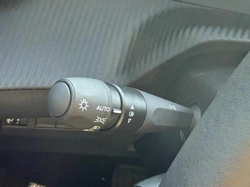 Gros plan sur la commande des phares et clignotants dans l’habitacle de la Peugeot 208 gris Selenium.